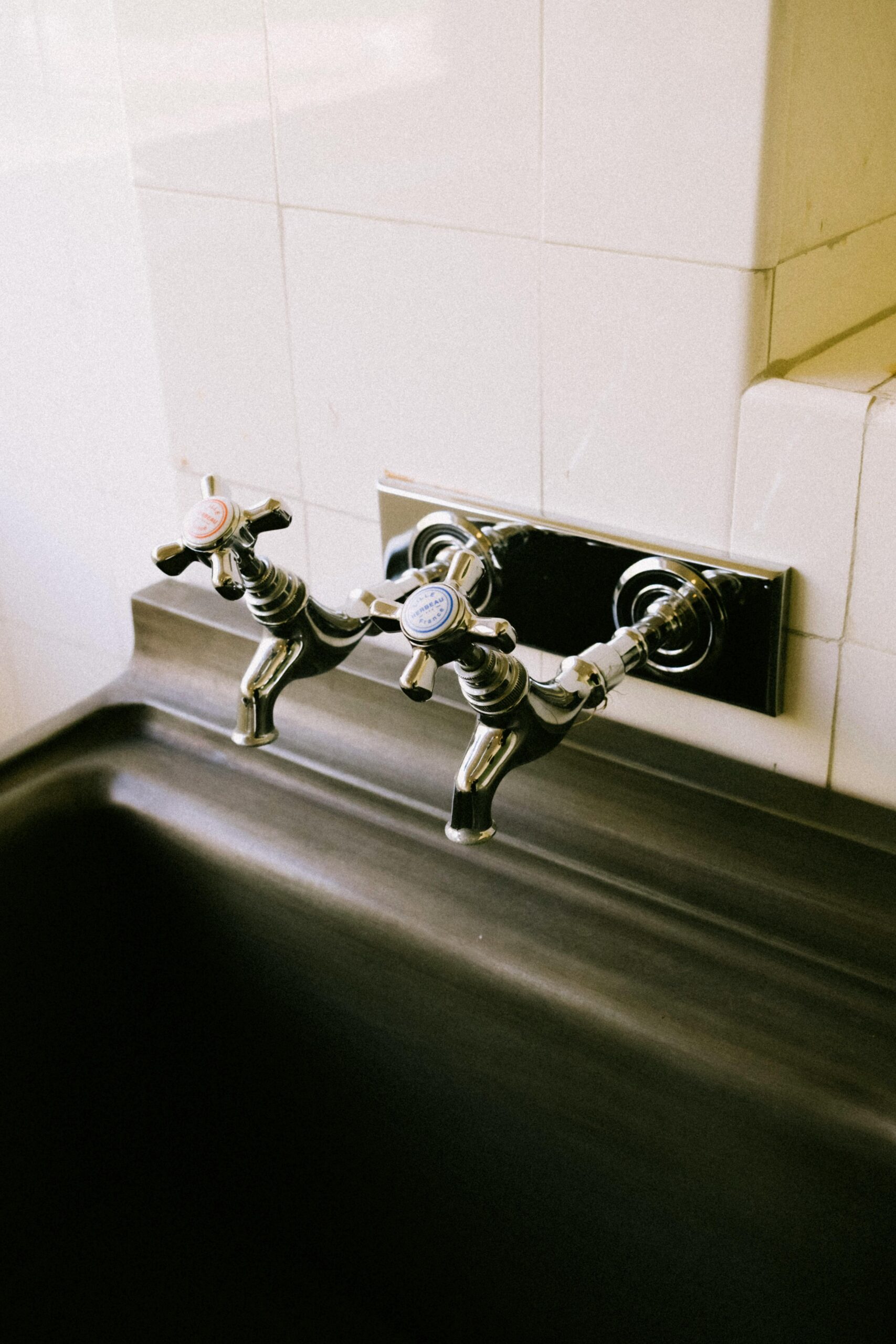 Stylish vintage chrome faucets over a sleek black sink, highlighting bathroom luxury.
