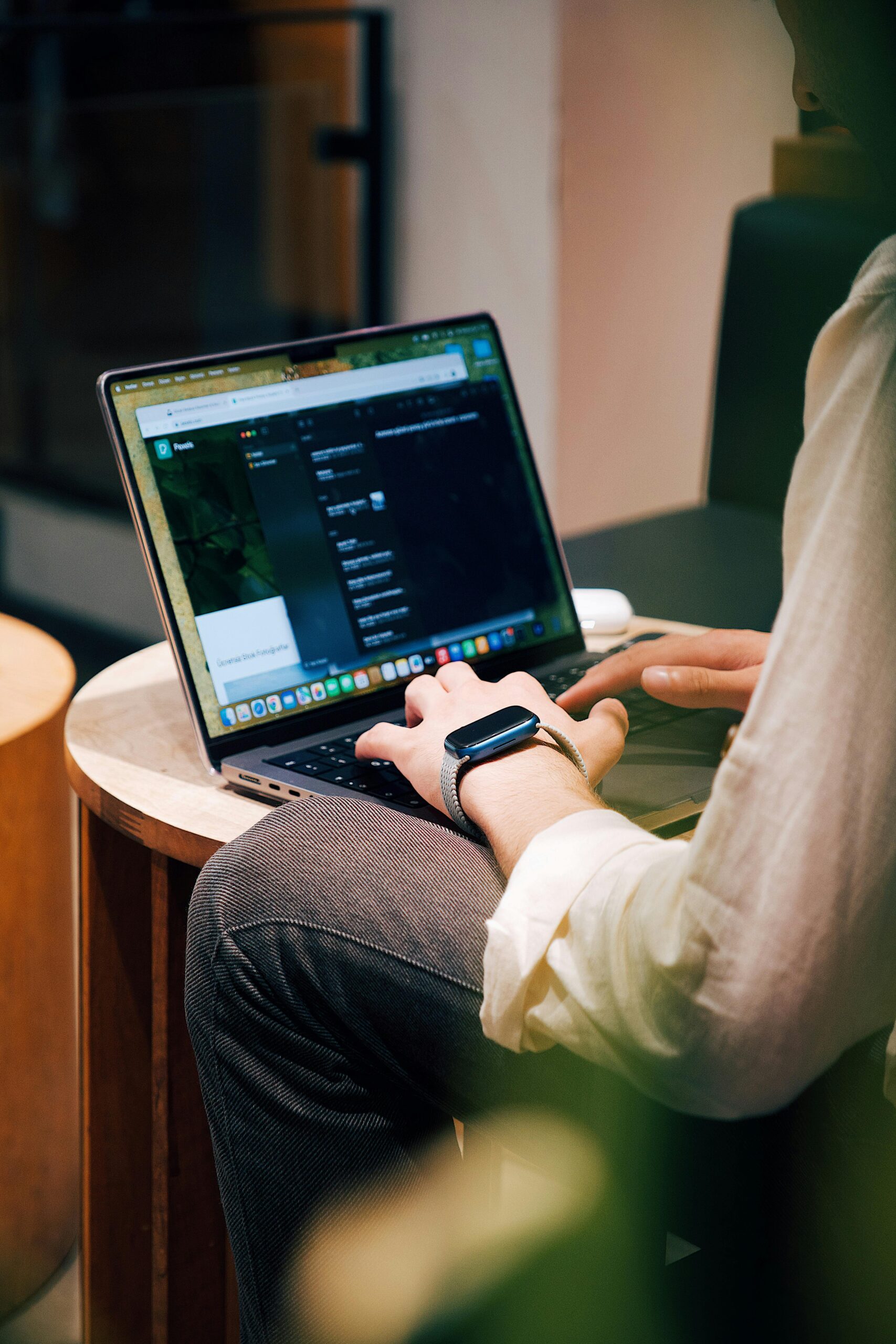 Adult using a laptop in a cozy cafe setting, showcasing modern work lifestyle.